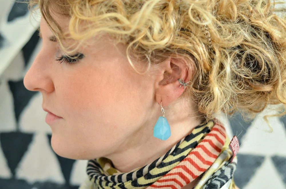 Ear cuff doré porté sur le cartilage de l'oreille, sans piercing.