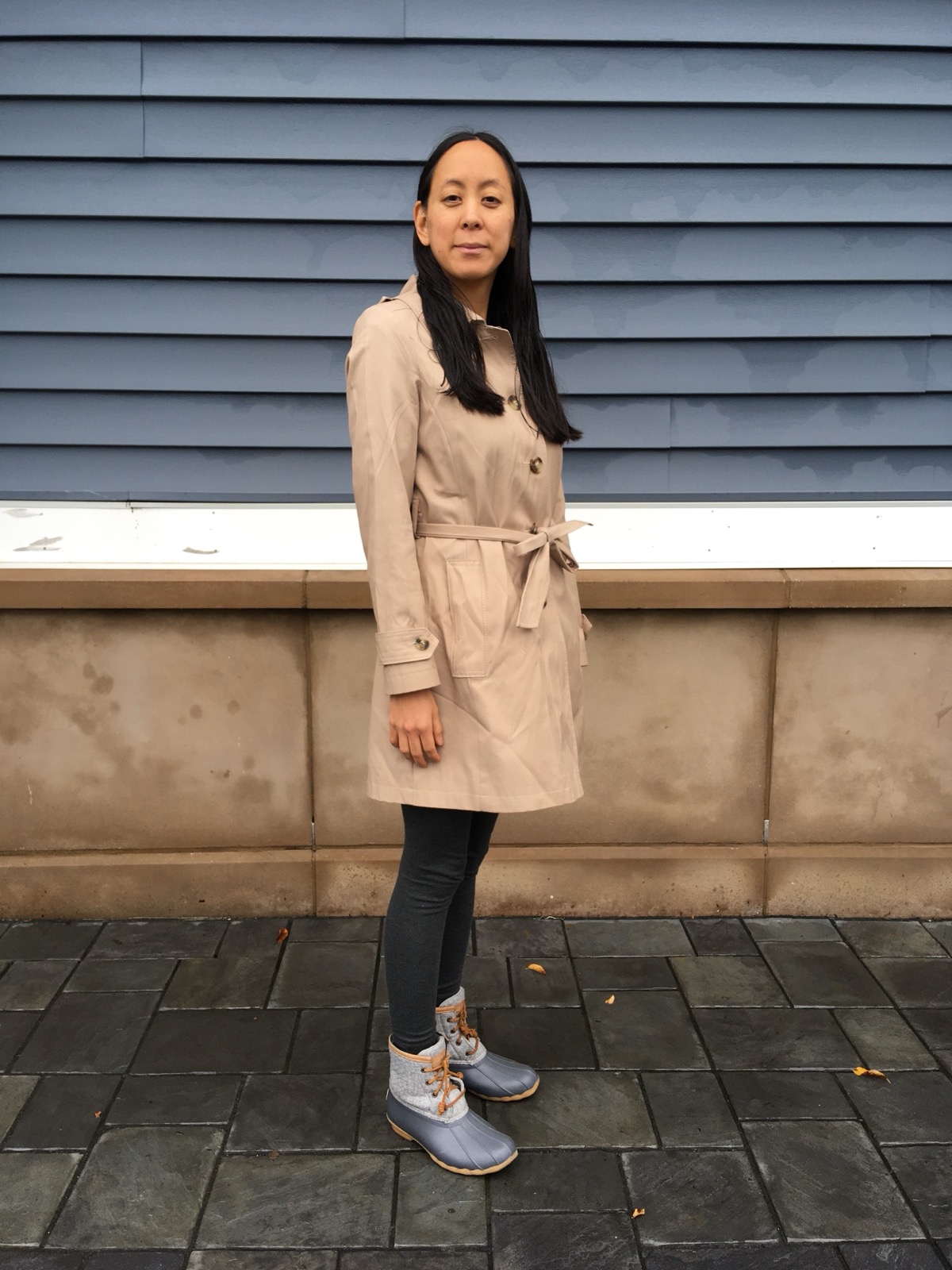 Femme portant un trench beige ceinturé en extérieur
