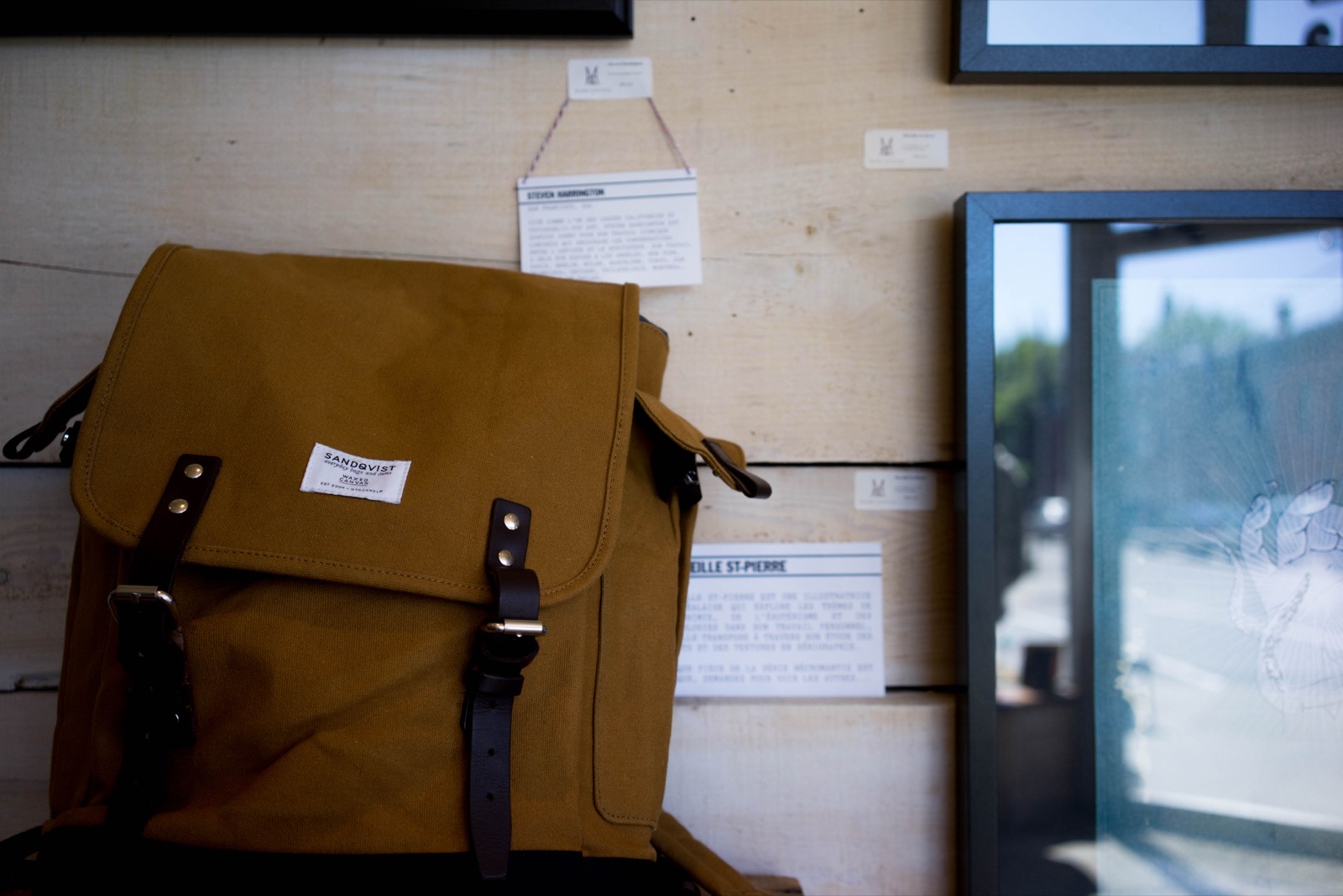 Sac à dos en toile et cuir marron Sandqvist posé dans une boutique
