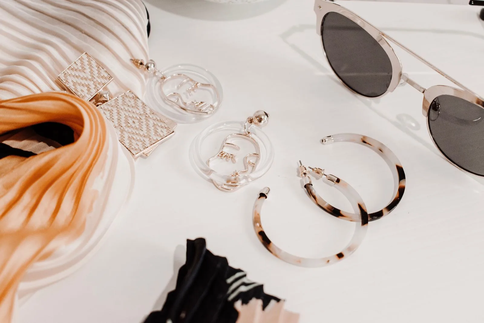 Composition d'accessoires de mode féminins, boucles d'oreilles et foulard, disposés à plat