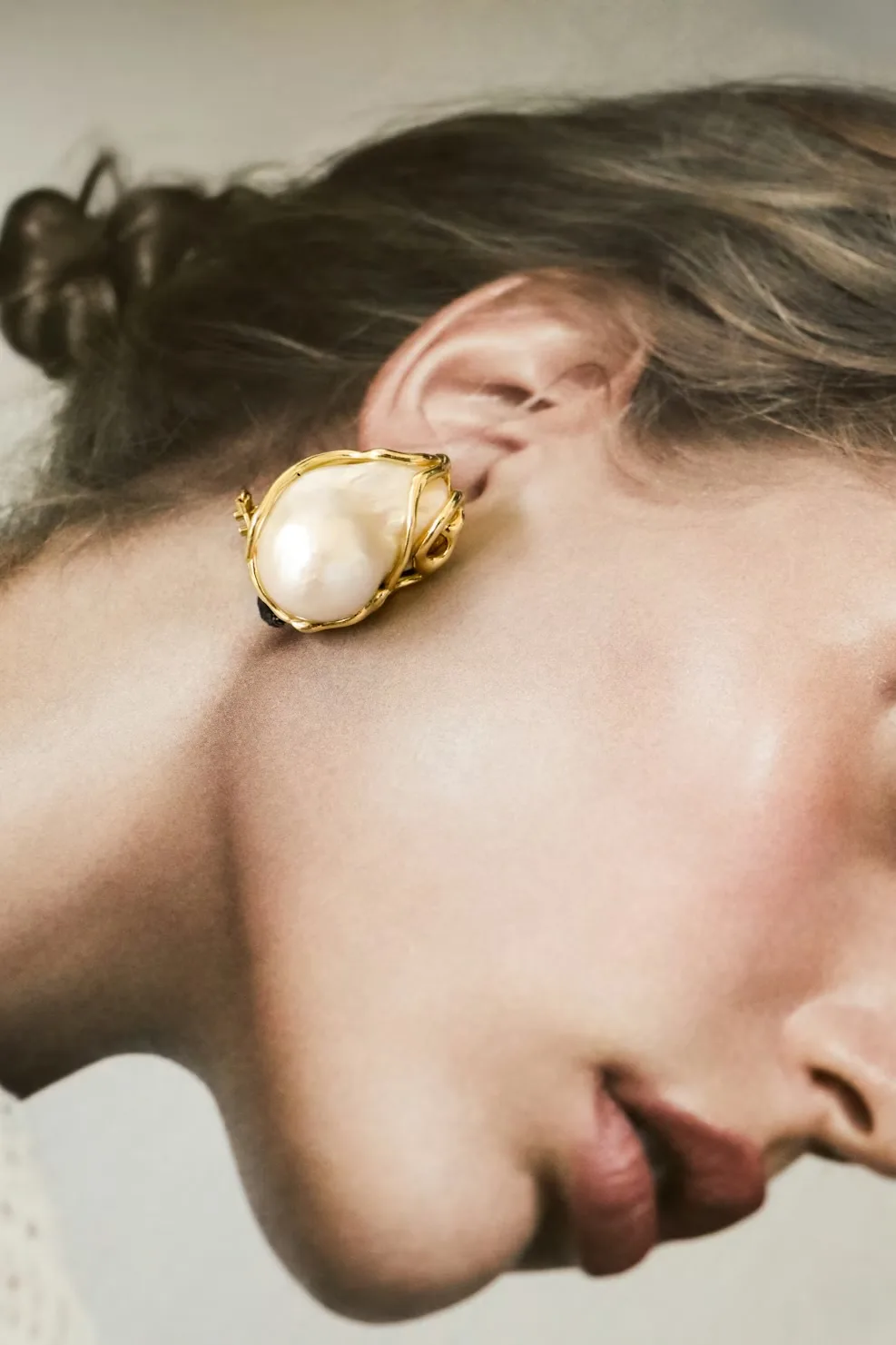 Boucles d'oreilles femme dorees presentees sur un fond minimaliste
