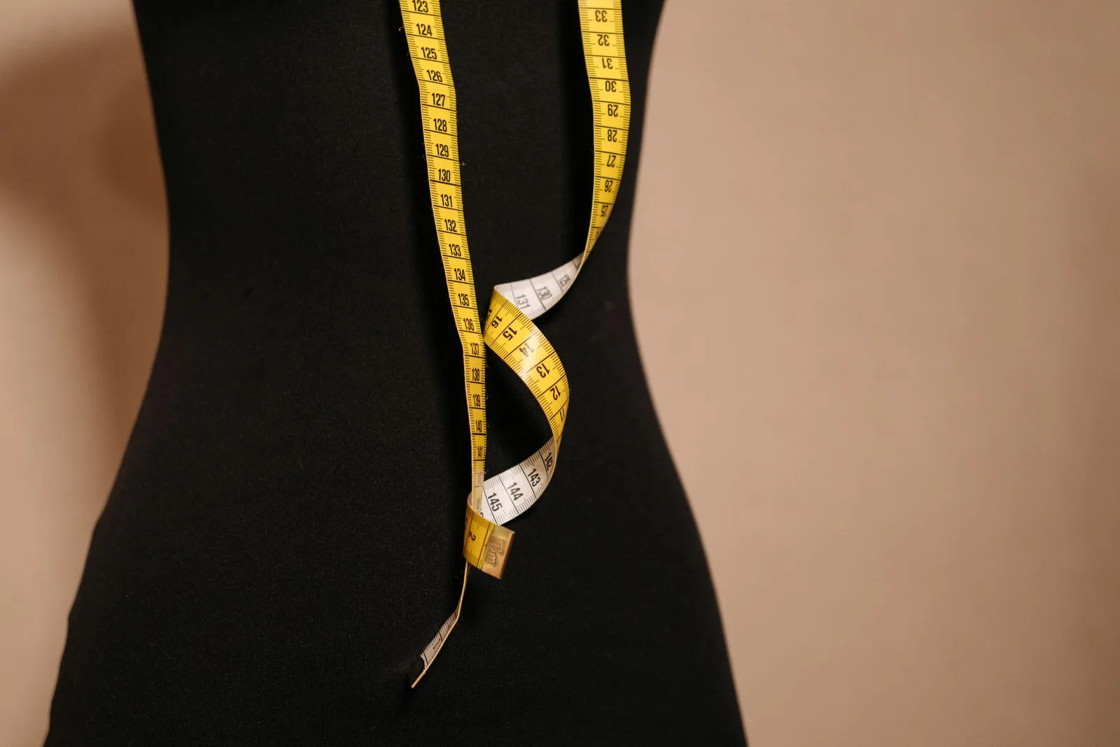 Buste de couture noir et mètre ruban jaune, symbole de la prise de mesures