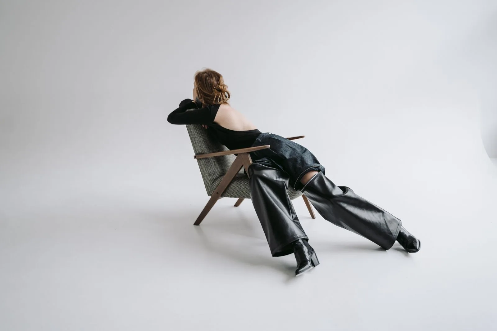 Femme en pantalon de cuir noir assise dans un studio
