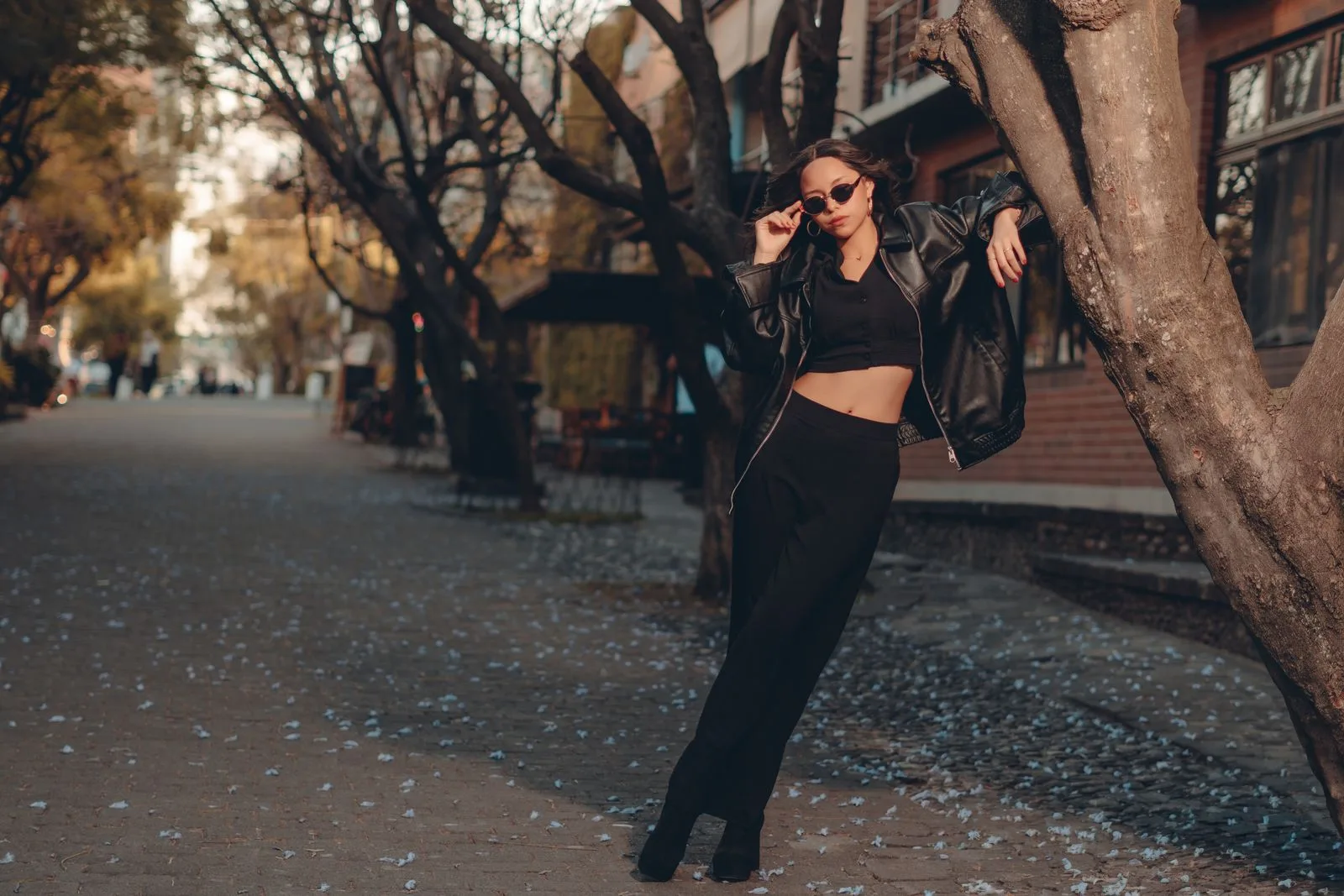 Femme en veste de cuir noir dans une rue en automne