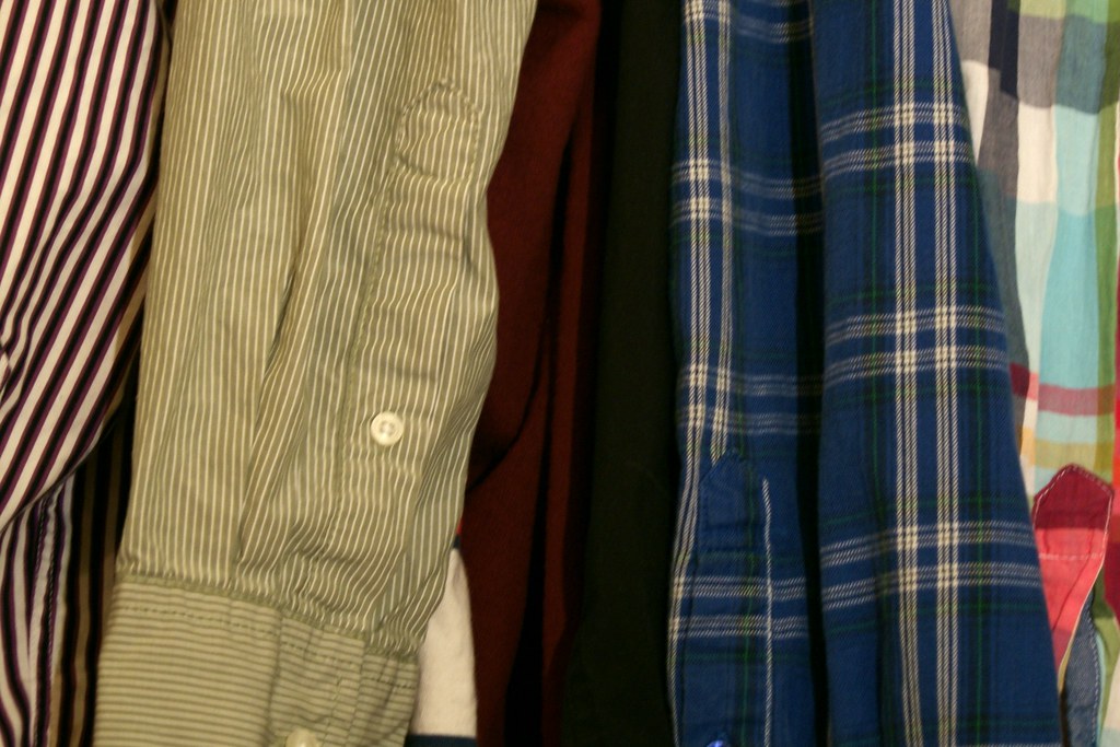 Men's shirts hanging in a wardrobe, choosing an office outfit