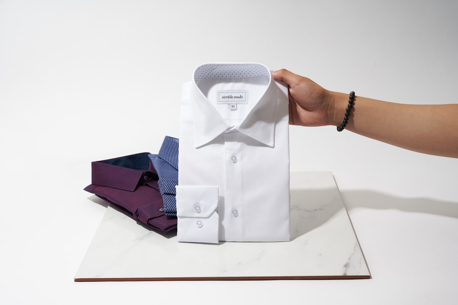 Ironed and folded men's shirts displayed on a rack, close-up on the fabric