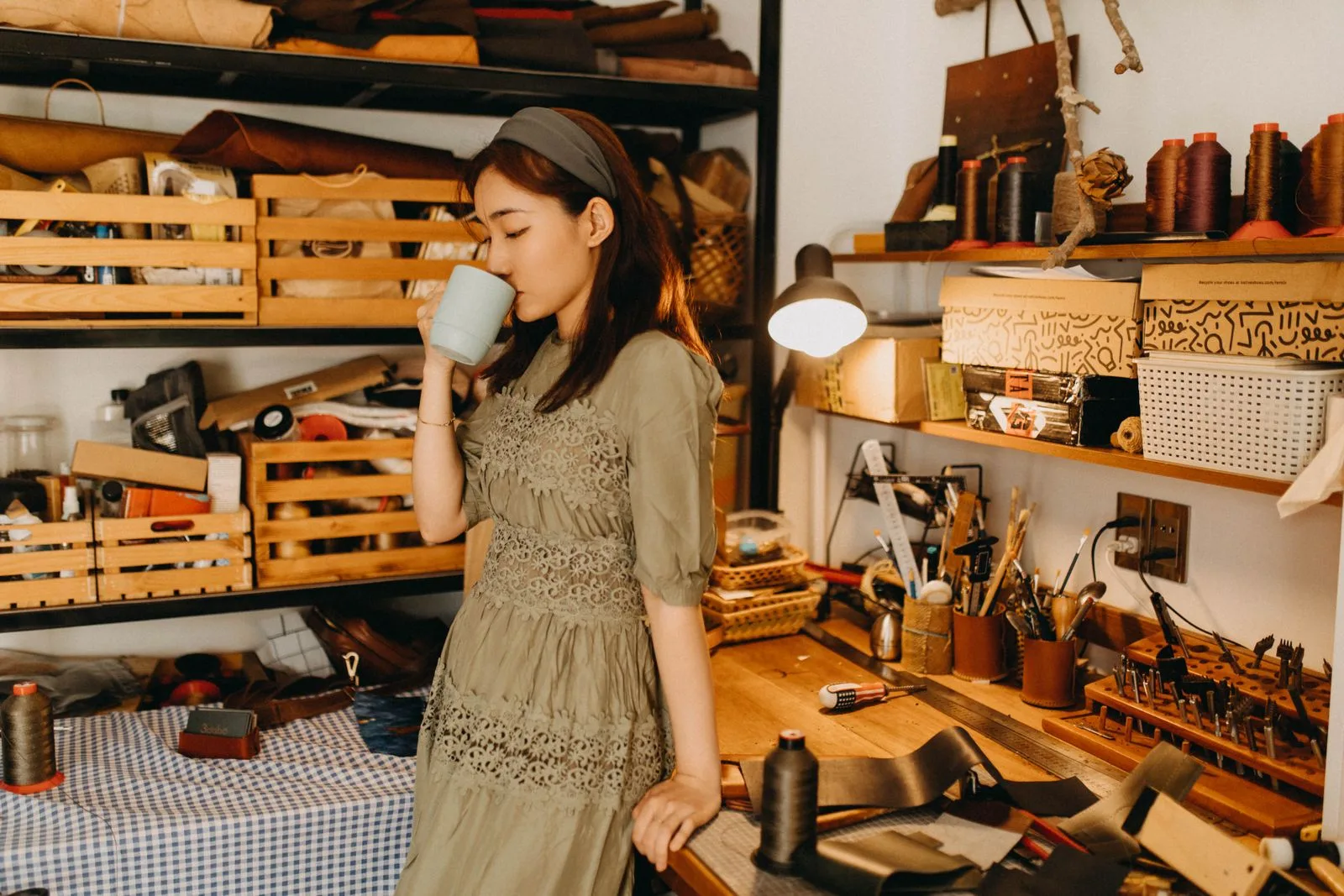 Woman in a leather workshop surrounded by hides and tools