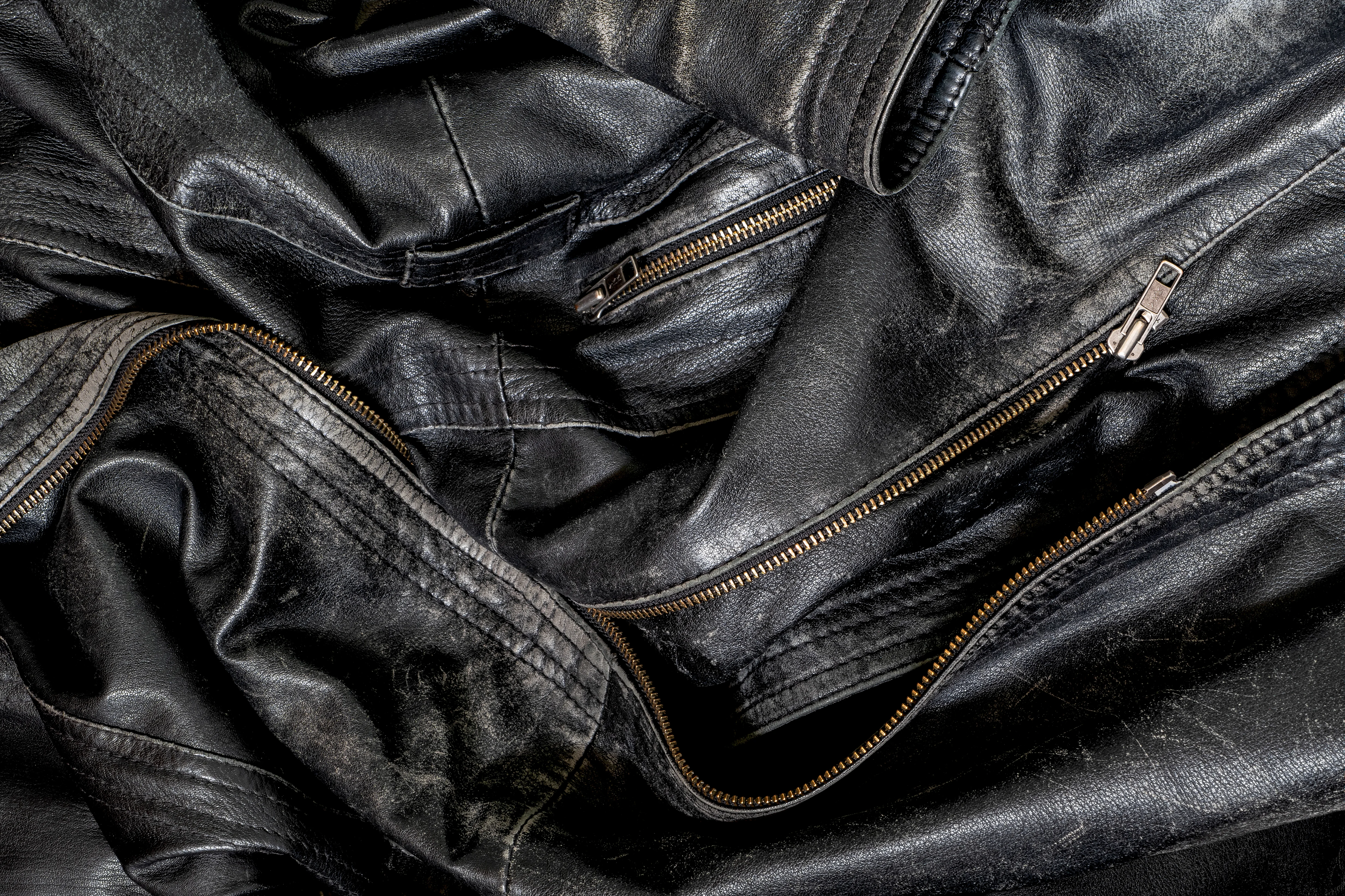 Détail d'une veste en cuir noir, coutures et fermetures à glissière