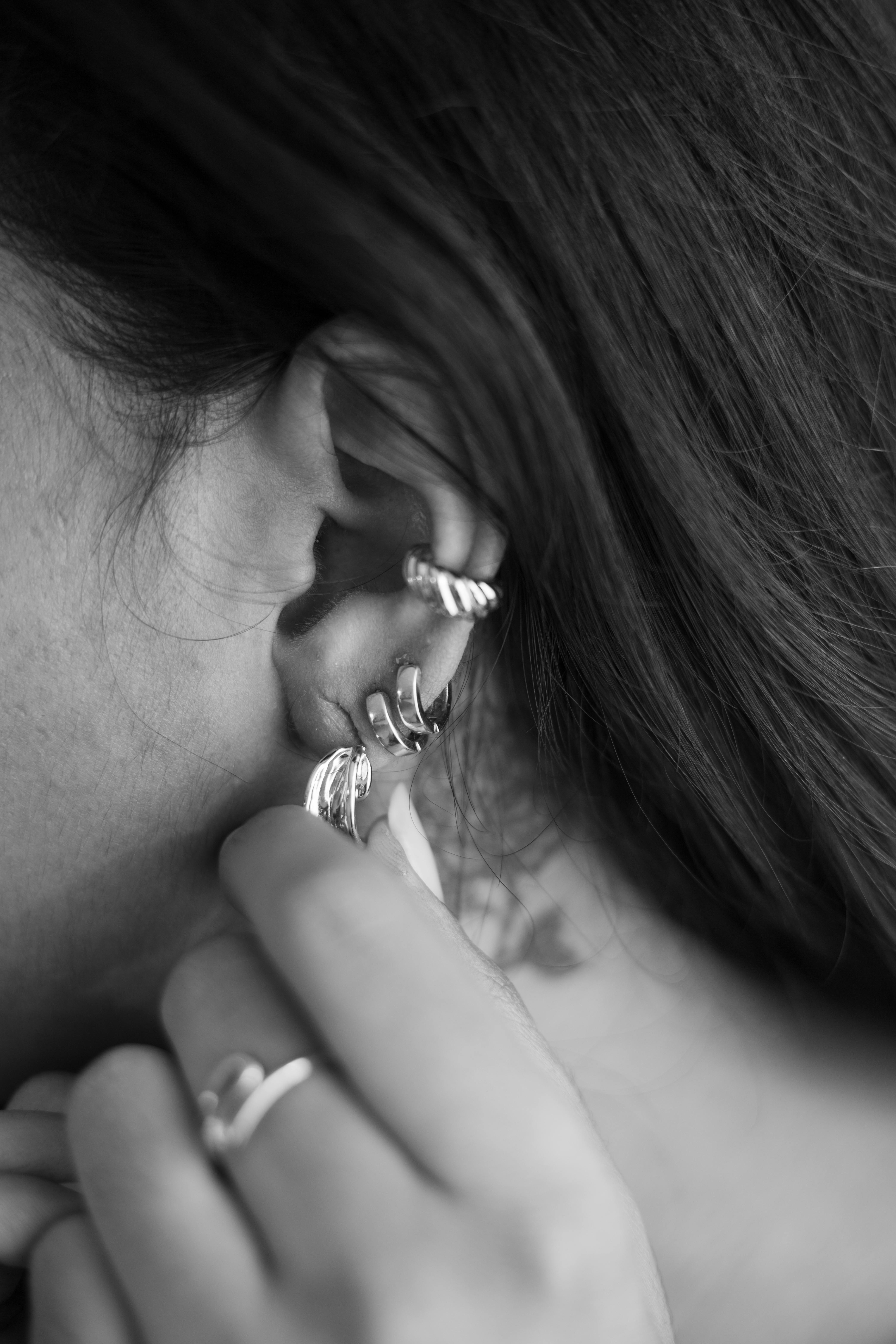 Ear cuff doré porté sur l'oreille, gros plan sur le bijou contemporain