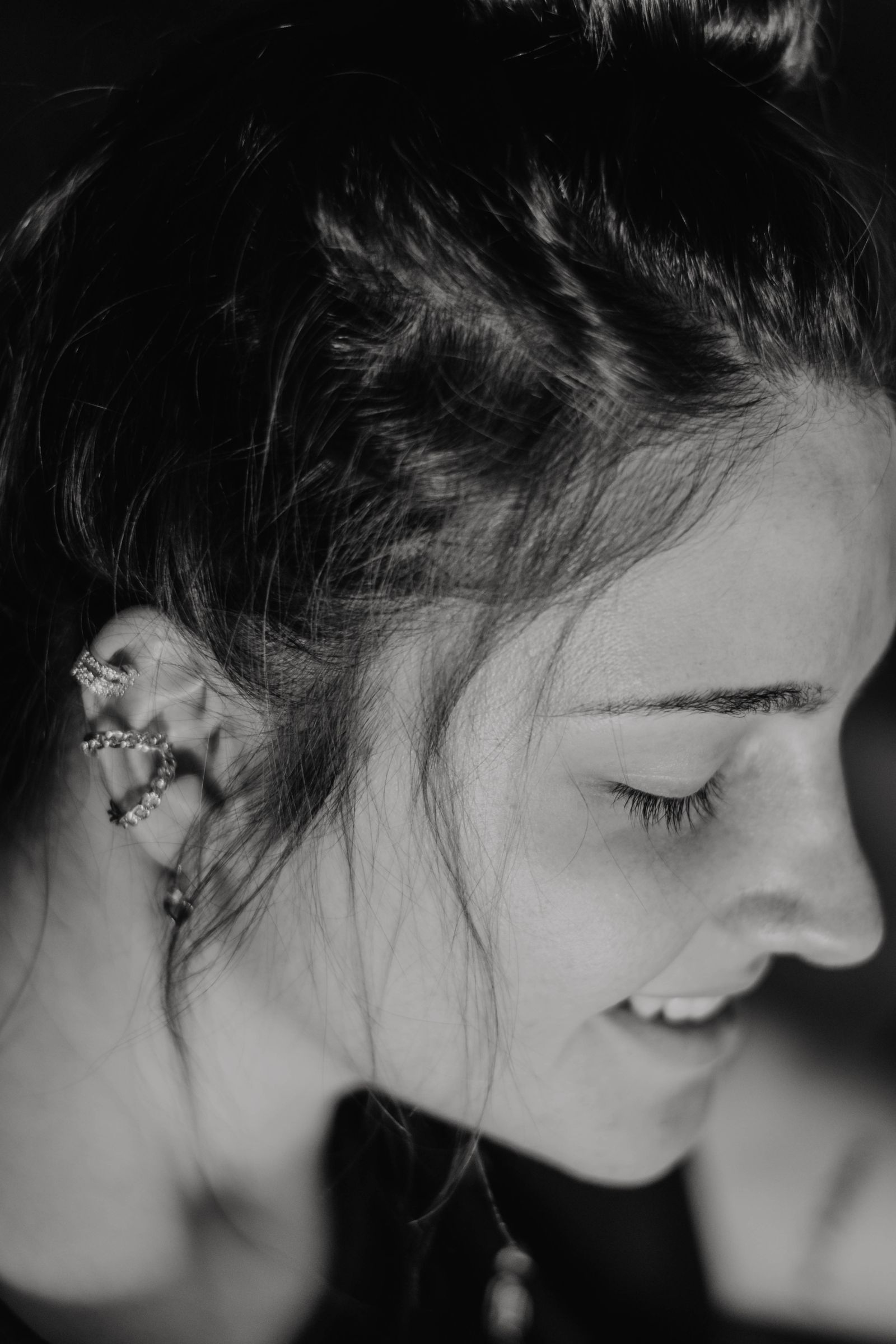 Profil en noir et blanc d'une femme portant plusieurs bijoux sur le cartilage de l'oreille, dont un hélix
