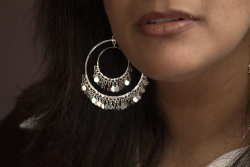 Woman wearing silver hoop earrings on the ear lobe