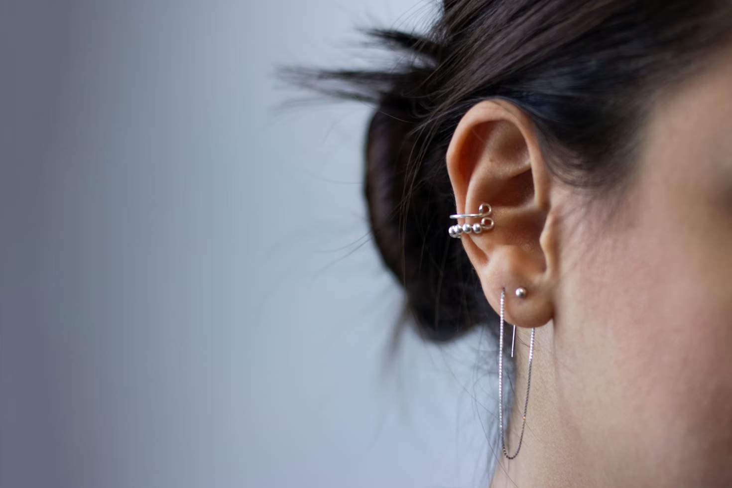 Oreille féminine avec ear cuff helix en argent et piercings de lobe