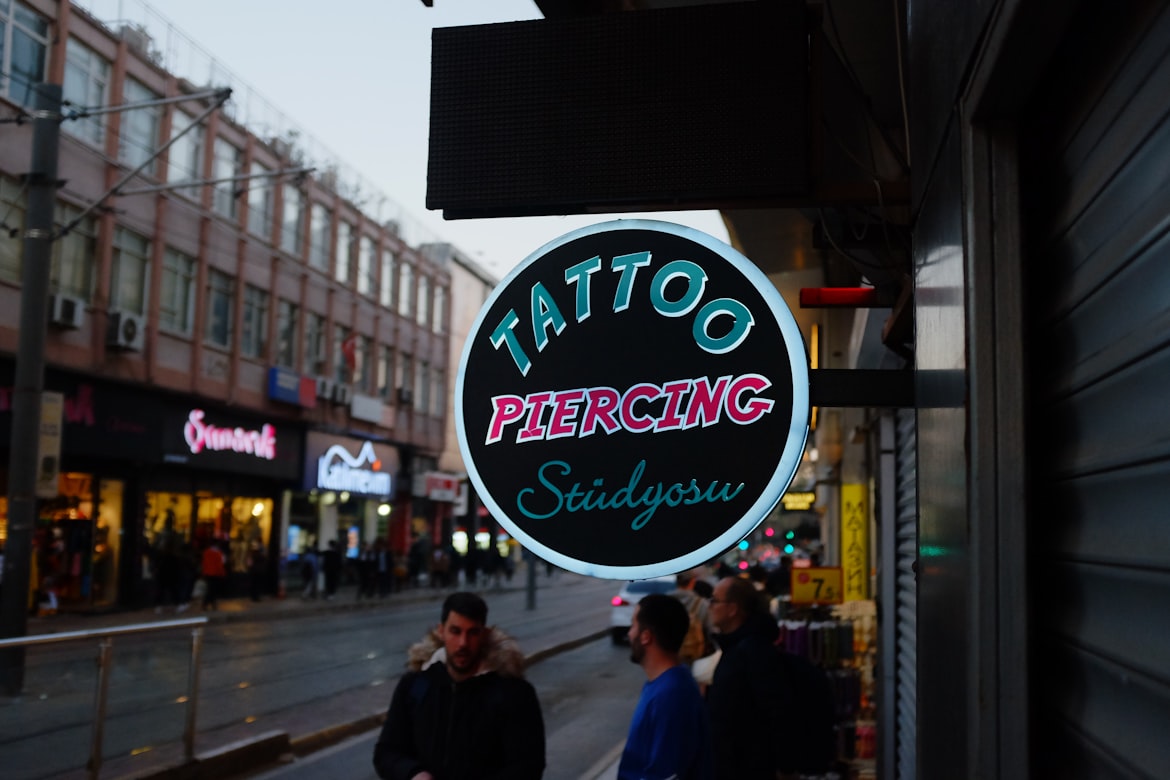 Enseigne lumineuse d'un salon de piercing en devanture de rue, illustrant le choix d'un studio professionnel